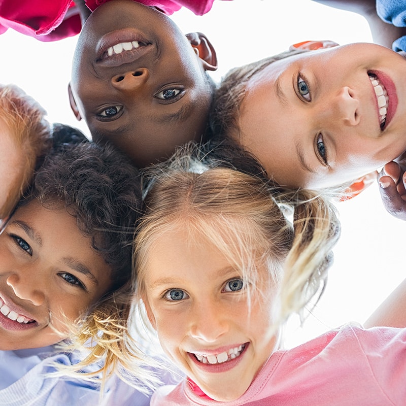 Happy-group-kids-huddled-smiling-down-camera Braces