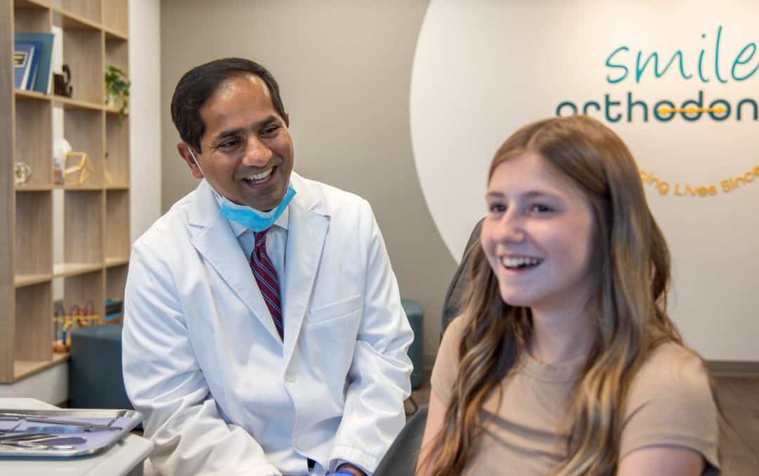 Friendly care at our andover orthodontics office Dentist smiling and talking with patient at orthodontics office near andover, ks